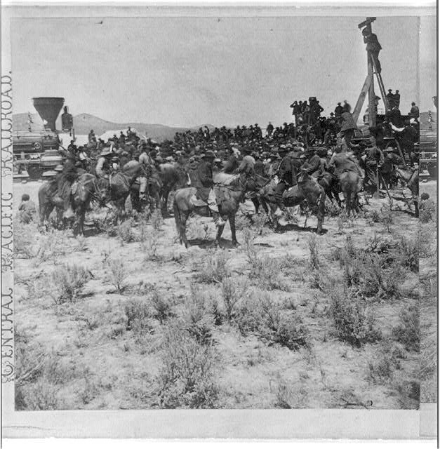 Crowd of railroad men and riders gathered around the locomotives as the last rail of the transcontinental railroad is laid, May 10, 1869 — photograph by Alfred A. Hart, Library of Congress