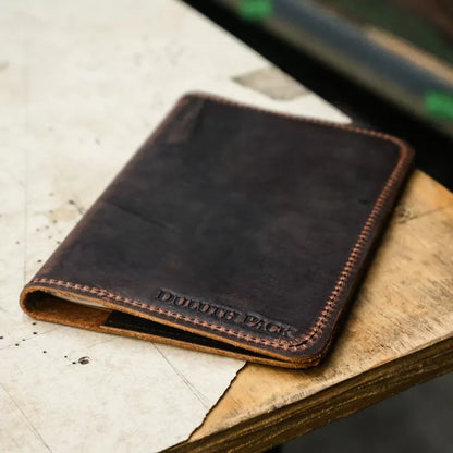 Brown leather wallet on a wooden surface with 'Duotone Pack' branding.