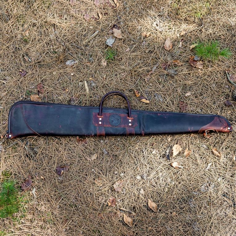 Leather gun case on a grassy ground
