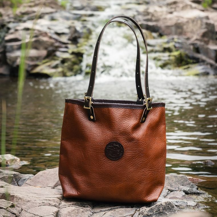 Brown leather handbag on a rock with a natural background